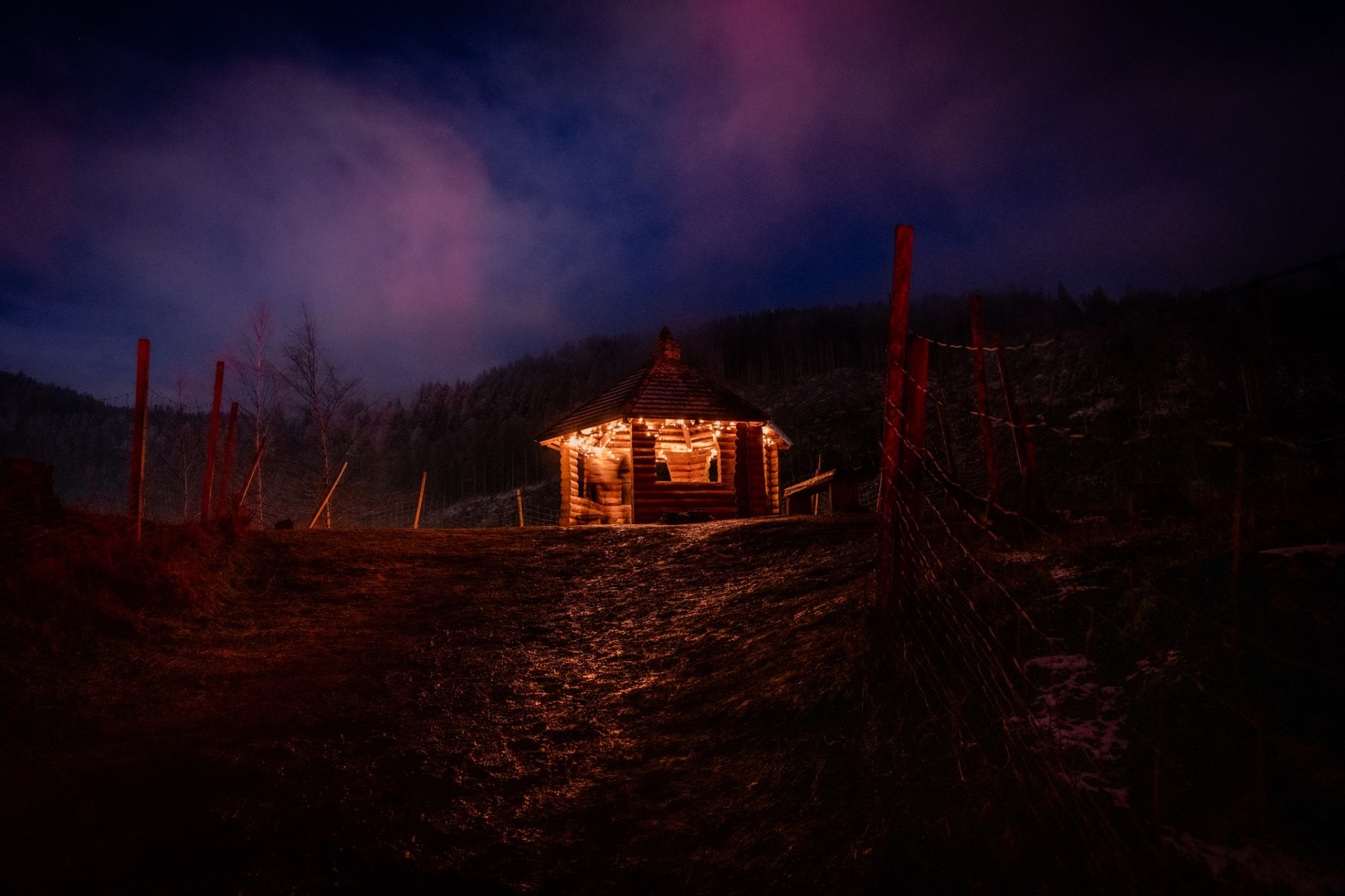 Beleuchtete Holzhütte am Winterweg nahe Weihnachtsmarkt Ravennaschlucht