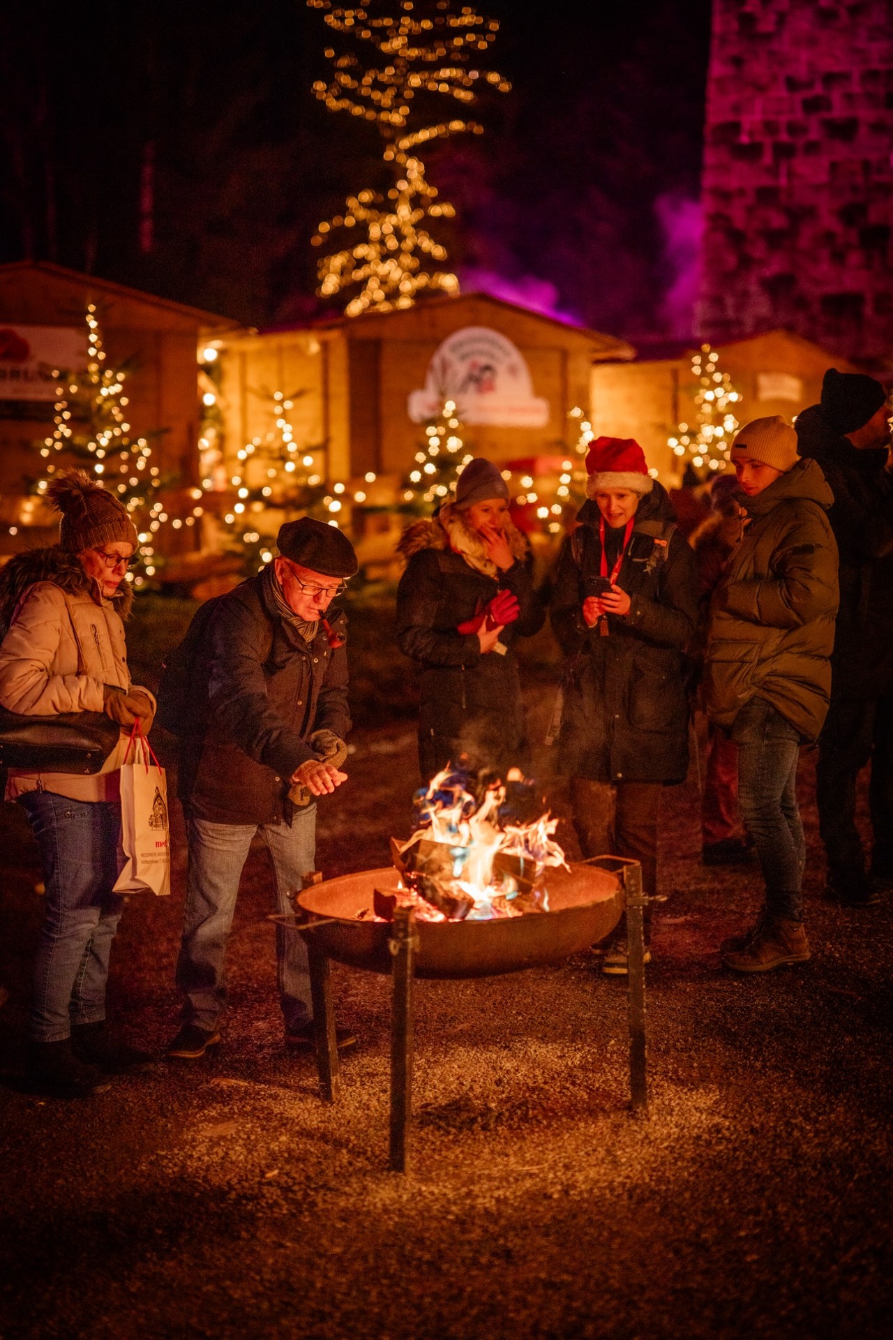 Besucherinnen und Besucher an einer Feuerschale auf dem Weihnachtsmarkt Ravennaschlucht