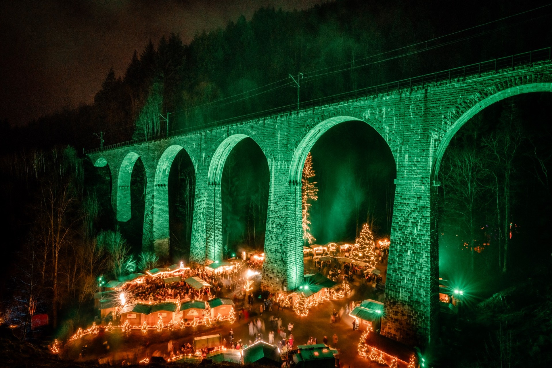 Grün beleuchtetes Höllentalviadukt über dem Weihnachtsmarkt Ravennaschlucht