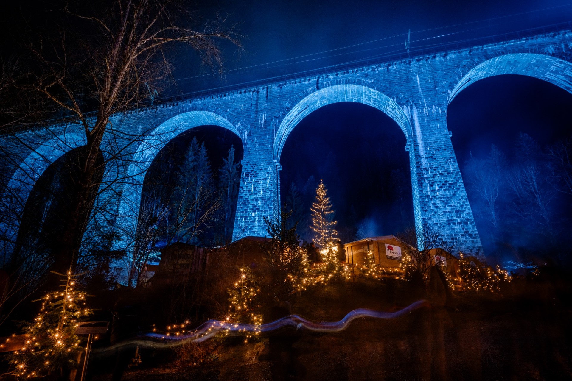 Weihnachtsmarkt Ravennaschlucht bei Nacht unter blauem Viadukt